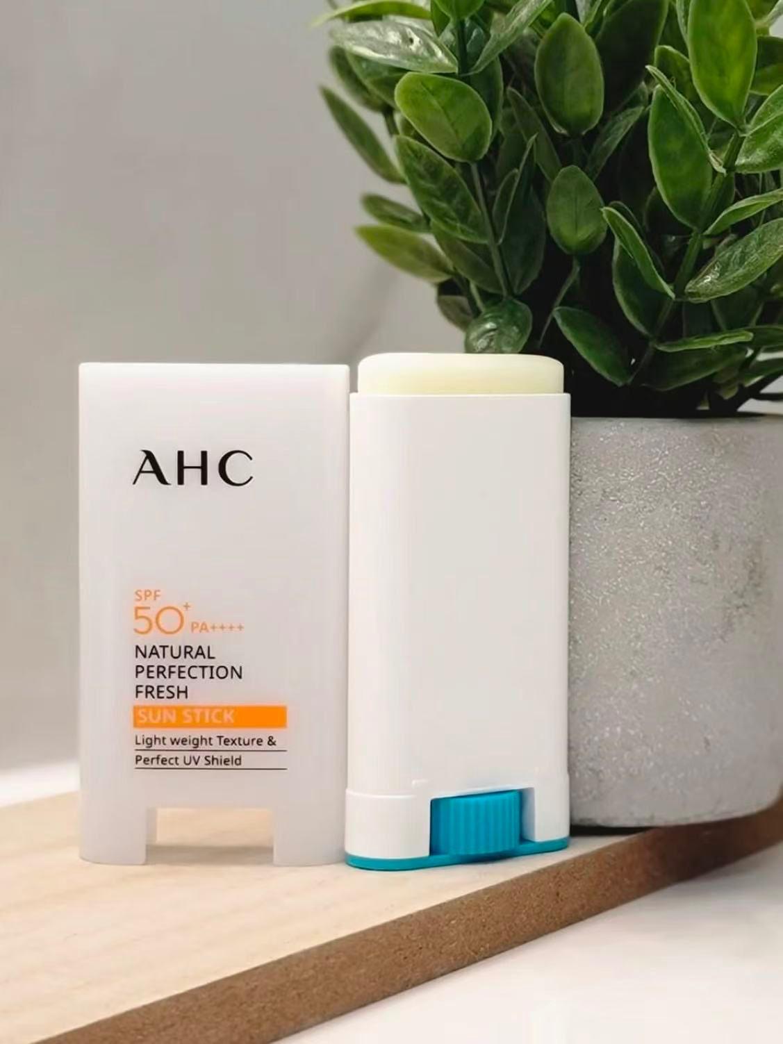 AHC 防晒棒手持使用特写，展示旋转出膏体与便携细节