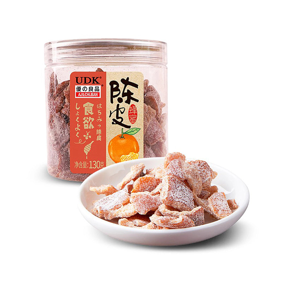 优之良品蜂蜜陈皮，背景为透明罐装陈皮，前景白色小碟盛放着裹有糖霜的陈皮干。