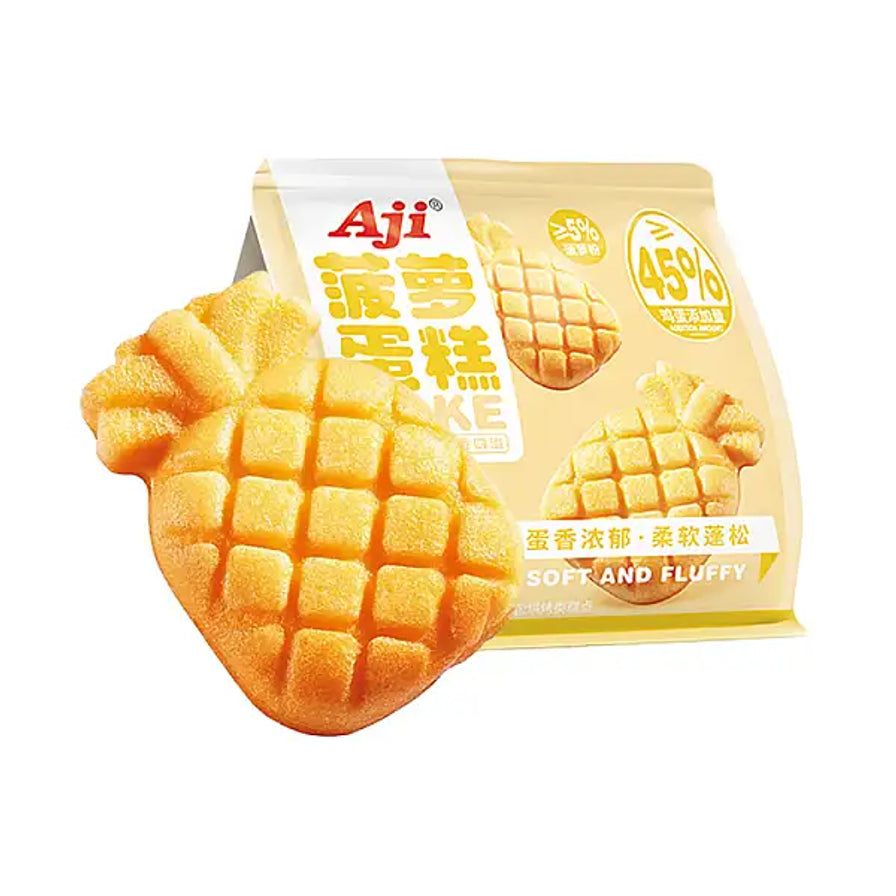 一块具有菠萝纹路的 Aji 菠萝蛋糕摆放在其黄色包装袋前，包装上标有 45% 鲜鸡蛋添加量。