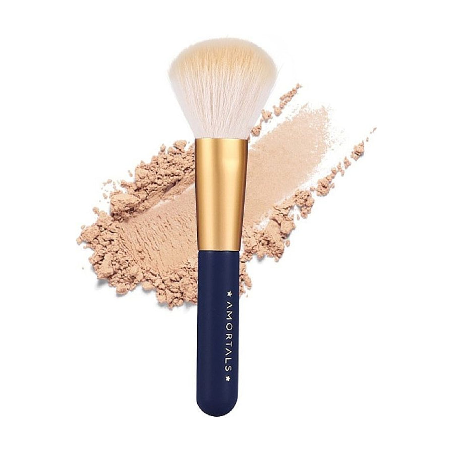 AMORTALS散粉刷特写，深蓝色手柄配金色管口，刷头沾有米色散粉并伴有试色痕迹。