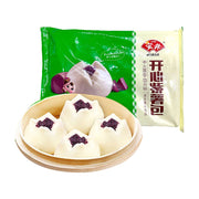 安井开心紫薯包包装袋与蒸笼中露出的四个紫薯包，展示白色松软外皮和紫色馅料。