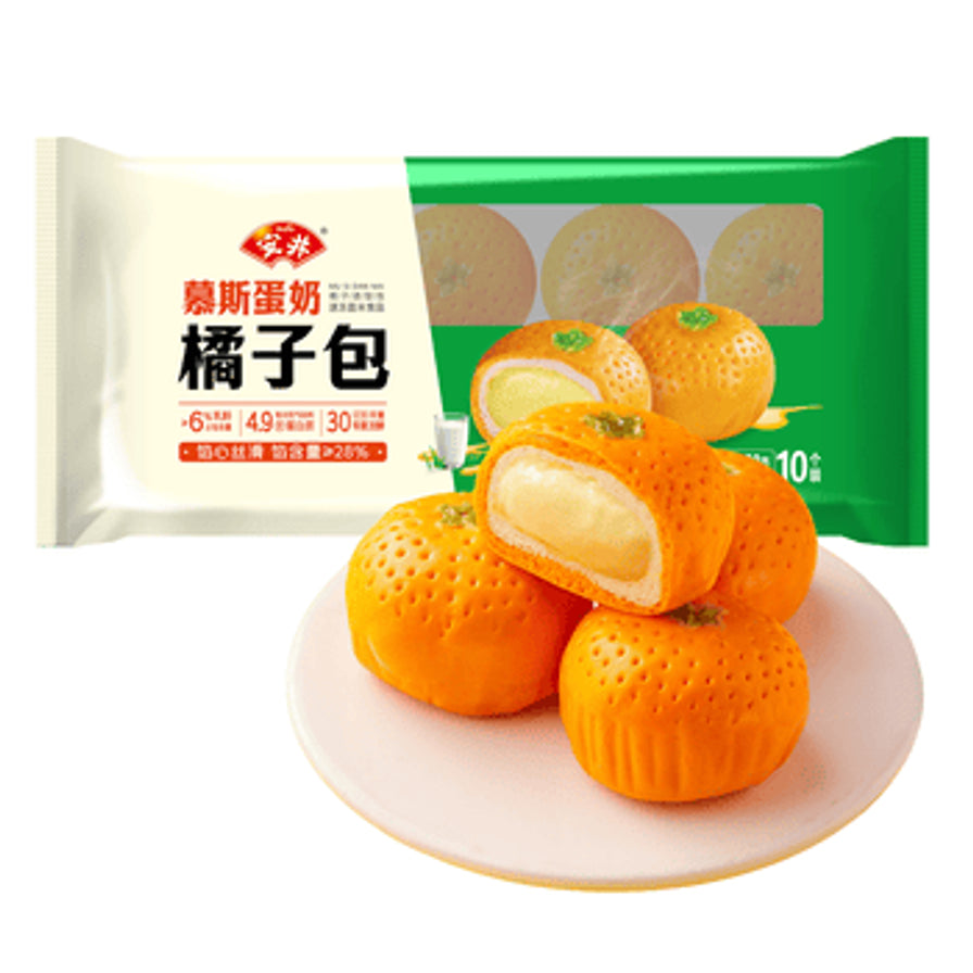 盘中盛放的安井橘子包，展示了橘子形状的逼真表皮纹理和切开后的慕斯蛋奶馅心，背景为产品包装。