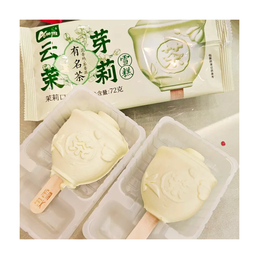 两支奥雪云芽茉莉雪糕实物特写，置于透明塑料托盘中，表面呈淡黄色茶壶浮雕造型，背景可见产品包装袋。