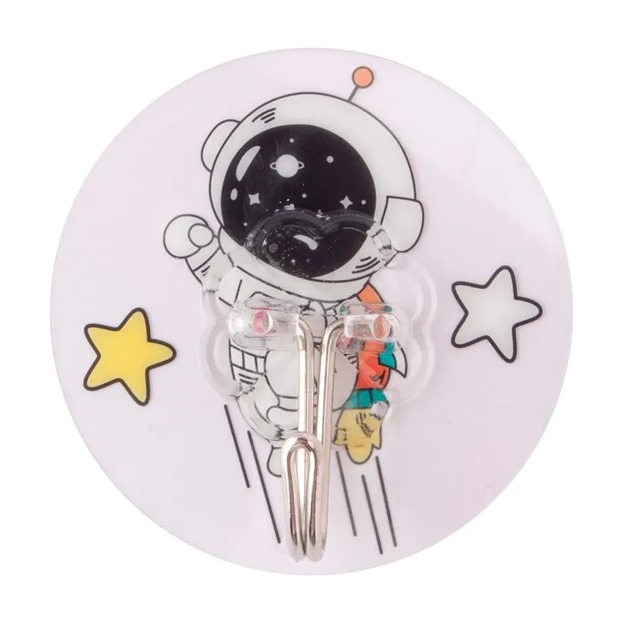 宇航员卡通图案圆形无痕粘钩特写，白色底座配黄色星星装饰，透明挂钩细节清晰可见。