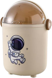 宇航员造型带盖垃圾桶正面图，白色机身搭配可爱卡通图案，适合桌面或床边使用