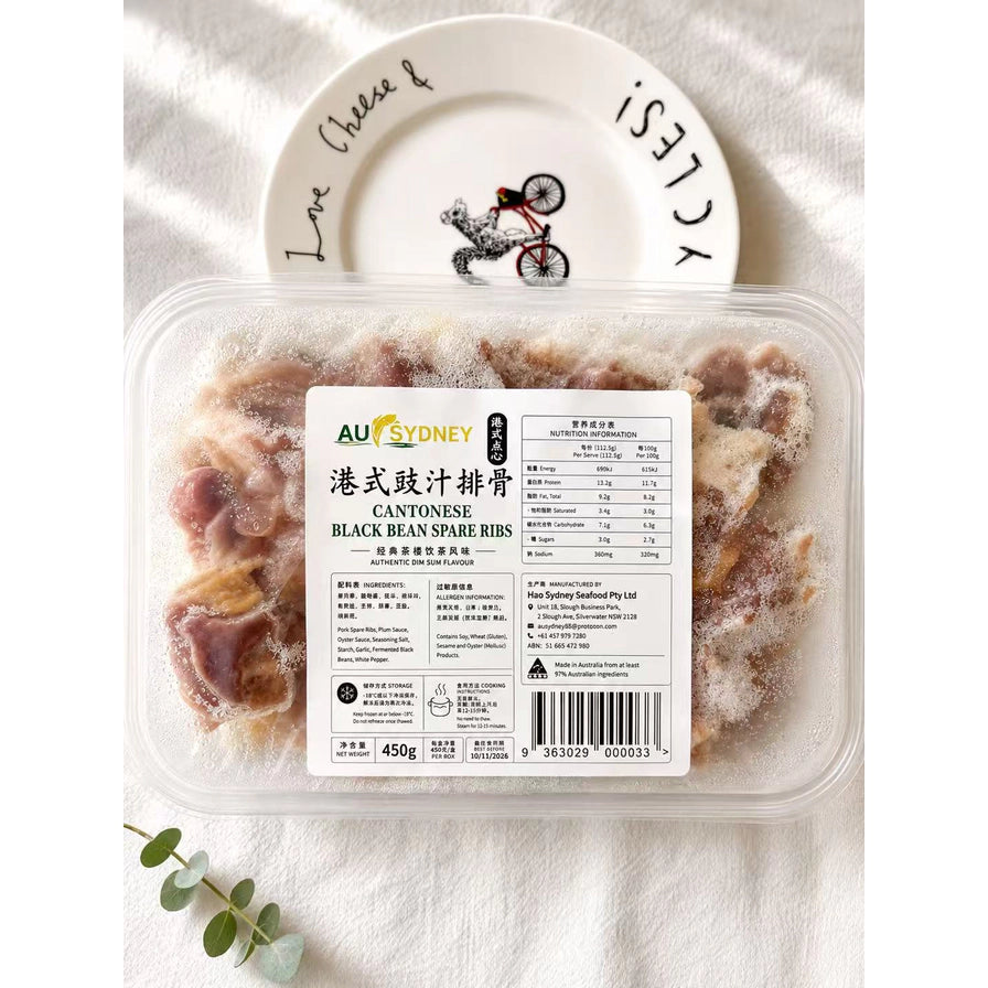 AU SYDNEY 港式豉汁蒸排骨 450g 盒装，背景配有装饰性圆盘和绿植，展示产品真实包装。
