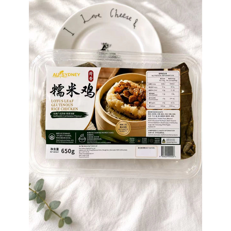 AU SYDNEY 港式瑶柱香菇瘦肉糯米鸡 650g 包装实拍图，放置在白色桌面上，背景有装饰性餐盘和绿植。