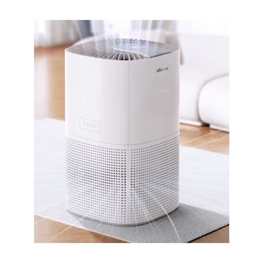 小熊空气净化器放置在浅色地毯上运行，展示其小巧的机身尺寸和出风效果。