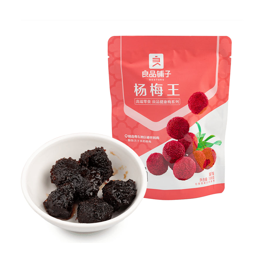 良品铺子杨梅王东魁硬丝杨梅包装袋，旁边白色小碗中盛放着数颗深红色、果肉饱满的杨梅干。