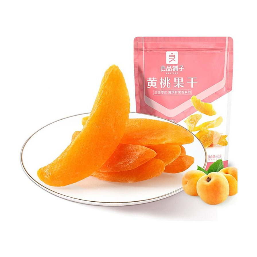 良品铺子黄桃果干包装袋与盘中厚实饱满的黄桃干，旁边配有新鲜黄桃。