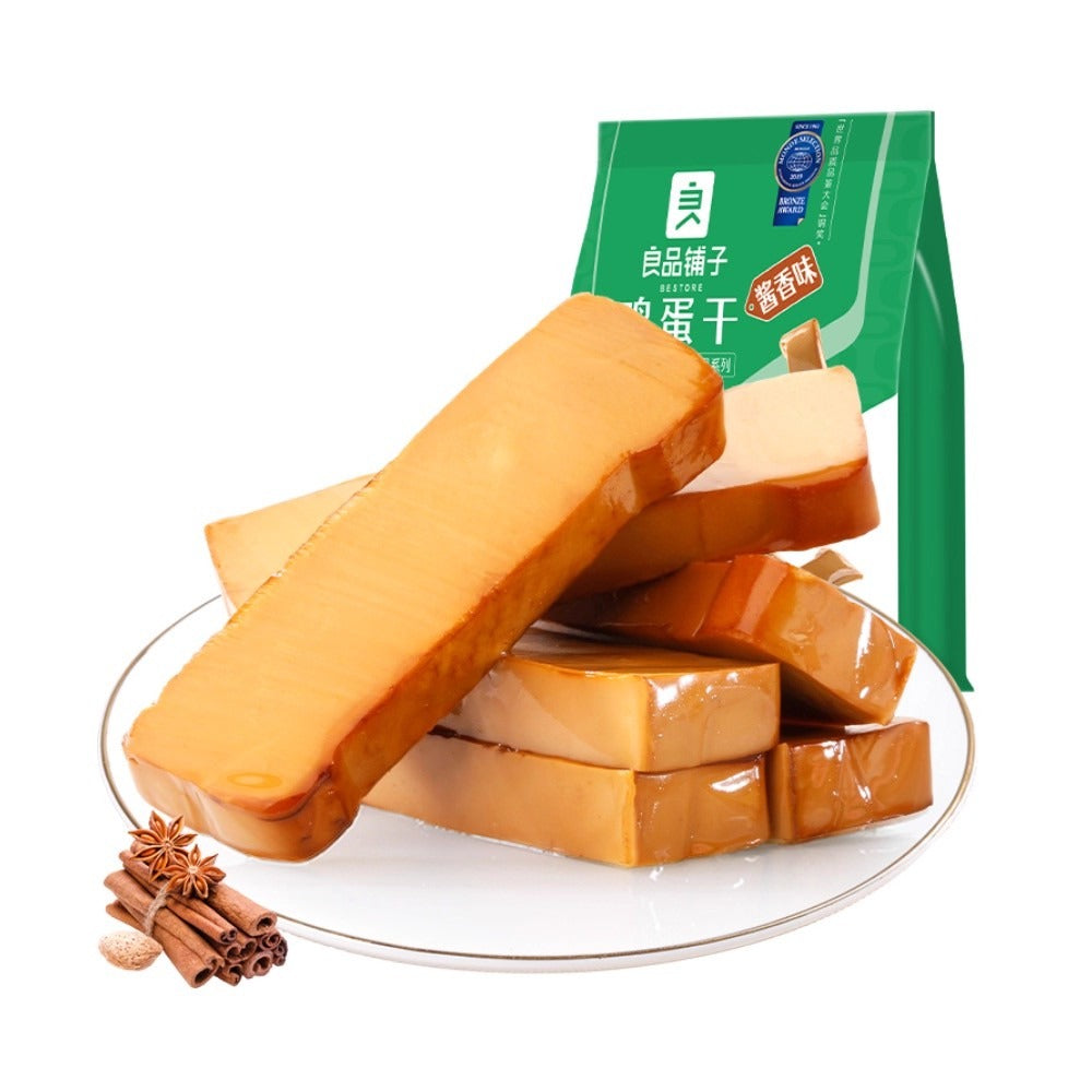 良品铺子鸡蛋干切片特写，展示 Q 弹紧实的质地与酱色光泽