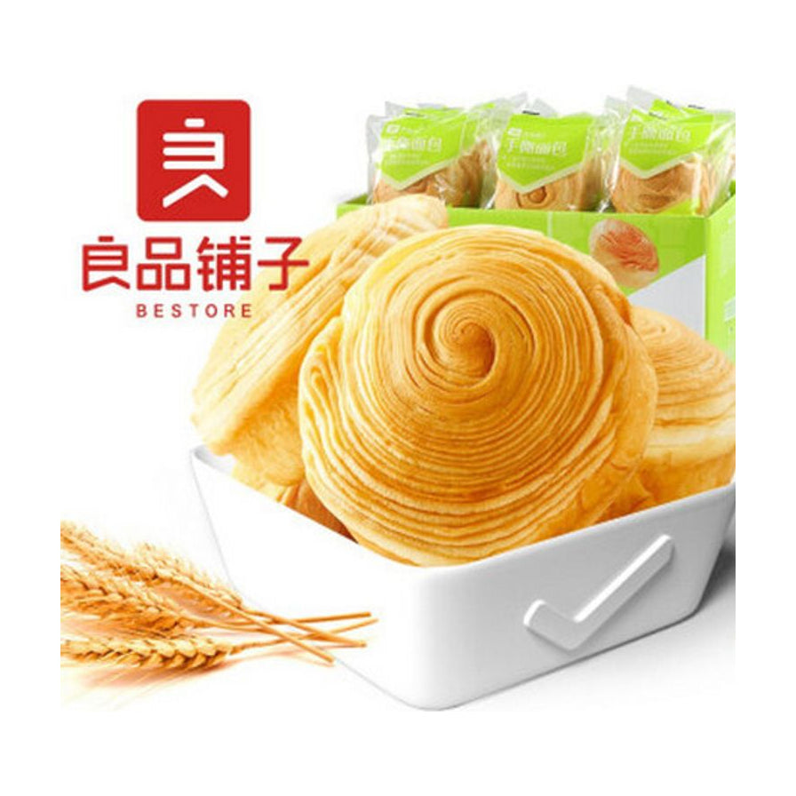 良品铺子手撕面包特写，展示了面包螺旋状的纹理，背景有白色托盘、麦穗装饰以及整箱独立包装的商品。