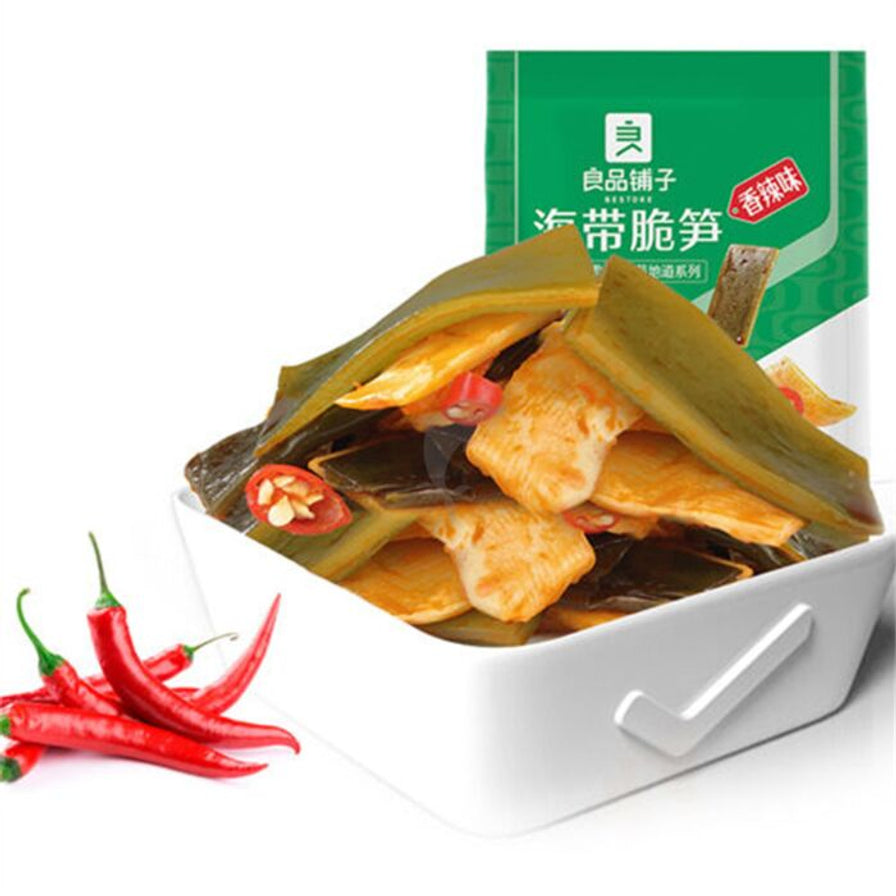 盛放在白色小碗中的良品铺子海带脆笋，展示了红油包裹的海带片和脆笋片，旁边配有新鲜红辣椒。