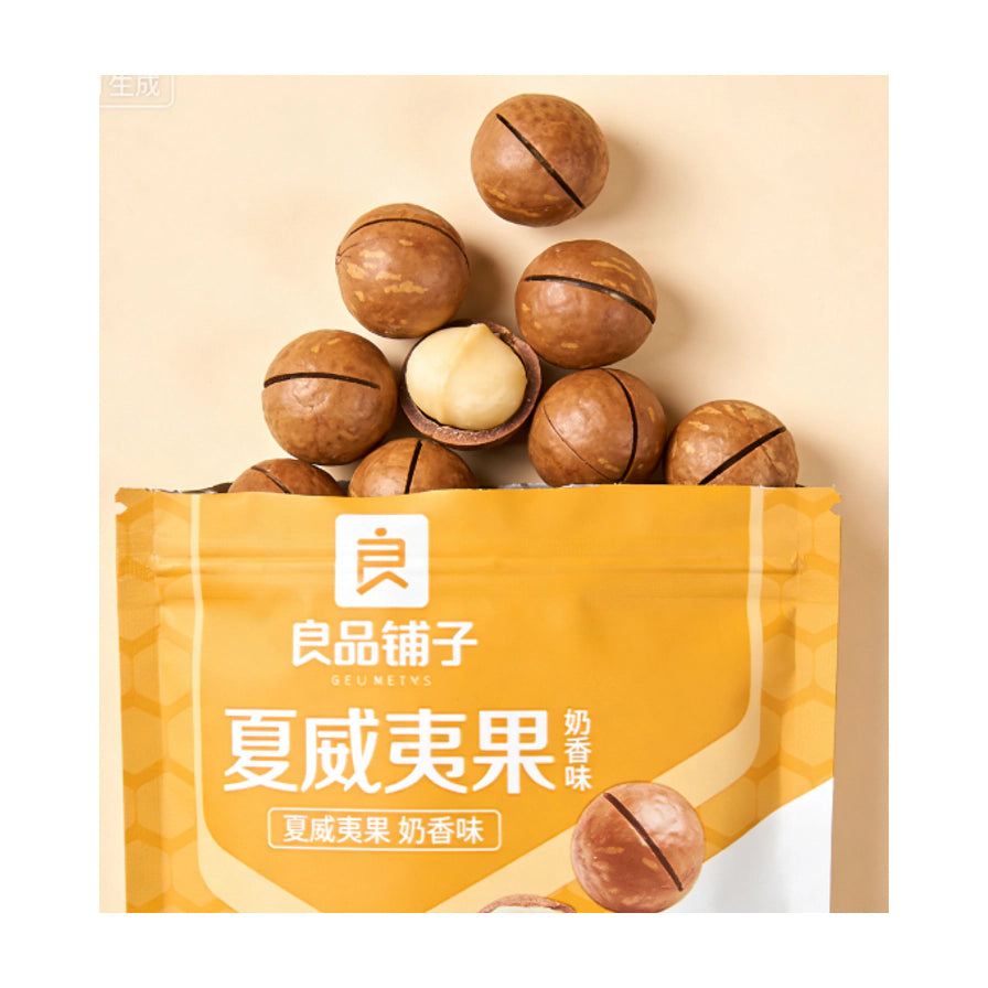 良品铺子奶香味夏威夷果近景，展示从包装袋中散落出的带壳夏威夷果，其中一颗已剥开露出乳白色果仁。