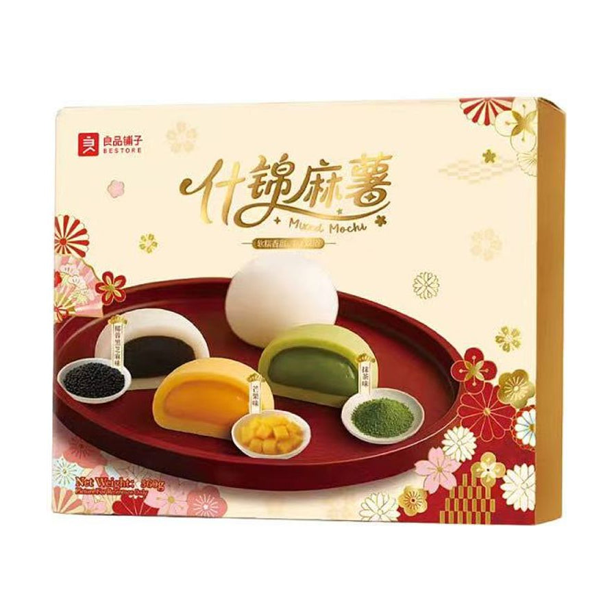 良品铺子什锦麻薯礼盒包装，展示了黑芝麻、芒果、抹茶等多种口味的剖面，质地软糯，配有精美和风花纹装饰。