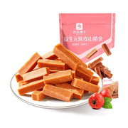 良品铺子益生元陈皮山楂条，白色圆盘中堆叠着长条状的山楂条，背景为粉色包装袋和新鲜山楂果。