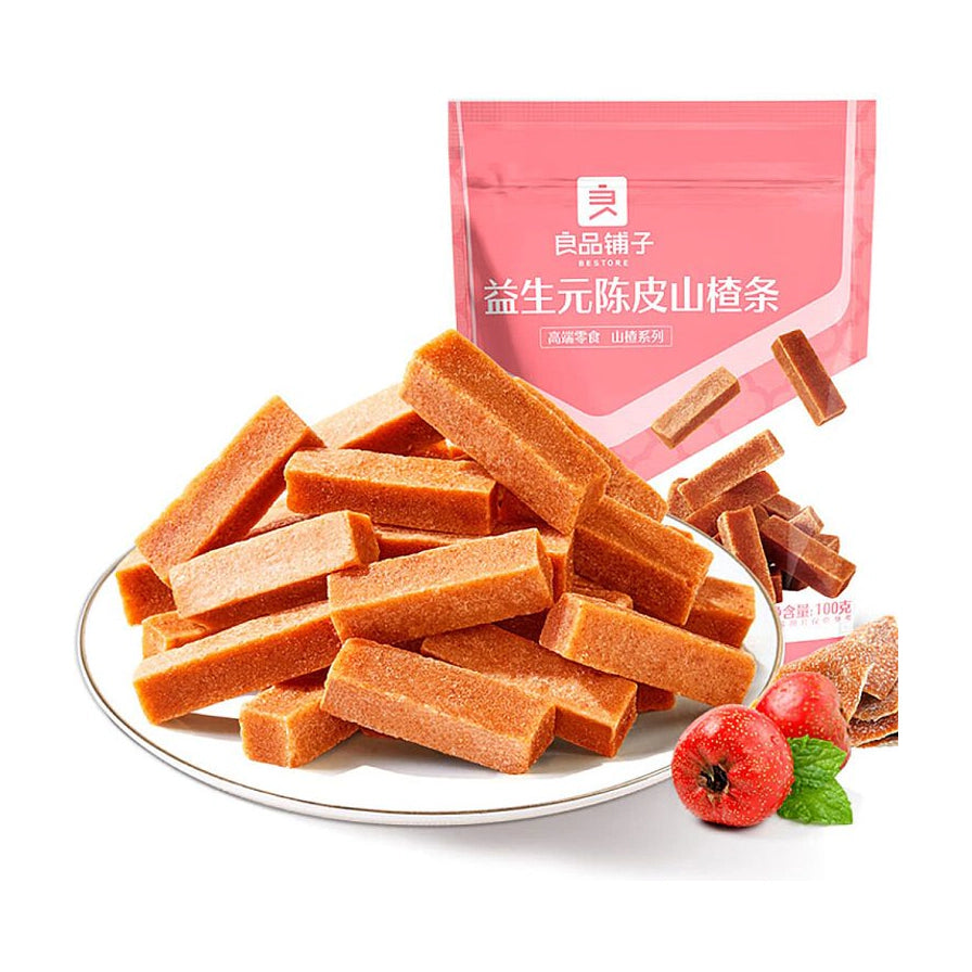 良品铺子益生元陈皮山楂条，白色圆盘中堆叠着长条状的山楂条，背景为粉色包装袋和新鲜山楂果。