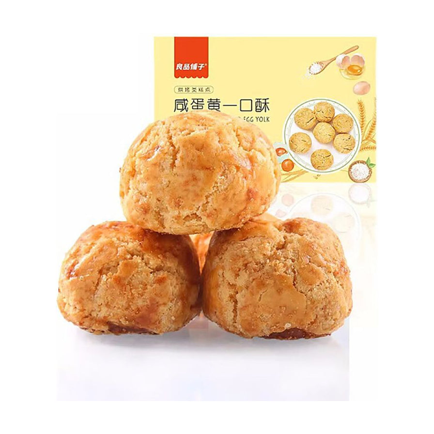 良品铺子咸蛋黄一口酥，特写展示三颗金黄酥脆的圆形糕点，背景带有品牌包装元素。