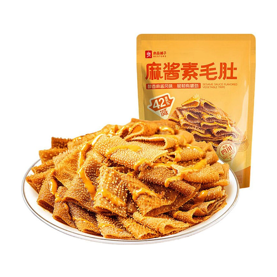 良品铺子麻酱素毛肚，盘中盛满裹满浓郁芝麻酱的Q弹魔芋素毛肚，背景为黄色包装袋。