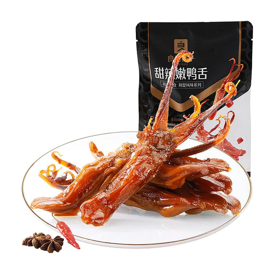 良品铺子甜辣嫩鸭舌，白色圆盘中盛放着色泽红亮、裹满酱汁的鸭舌，背景为黑色包装袋，旁边点缀有干辣椒和八角。