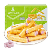 良品铺子香芋注心蛋卷包装盒与一盘堆叠的酥脆蛋卷，展示紫色香芋内馅和芋头块。
