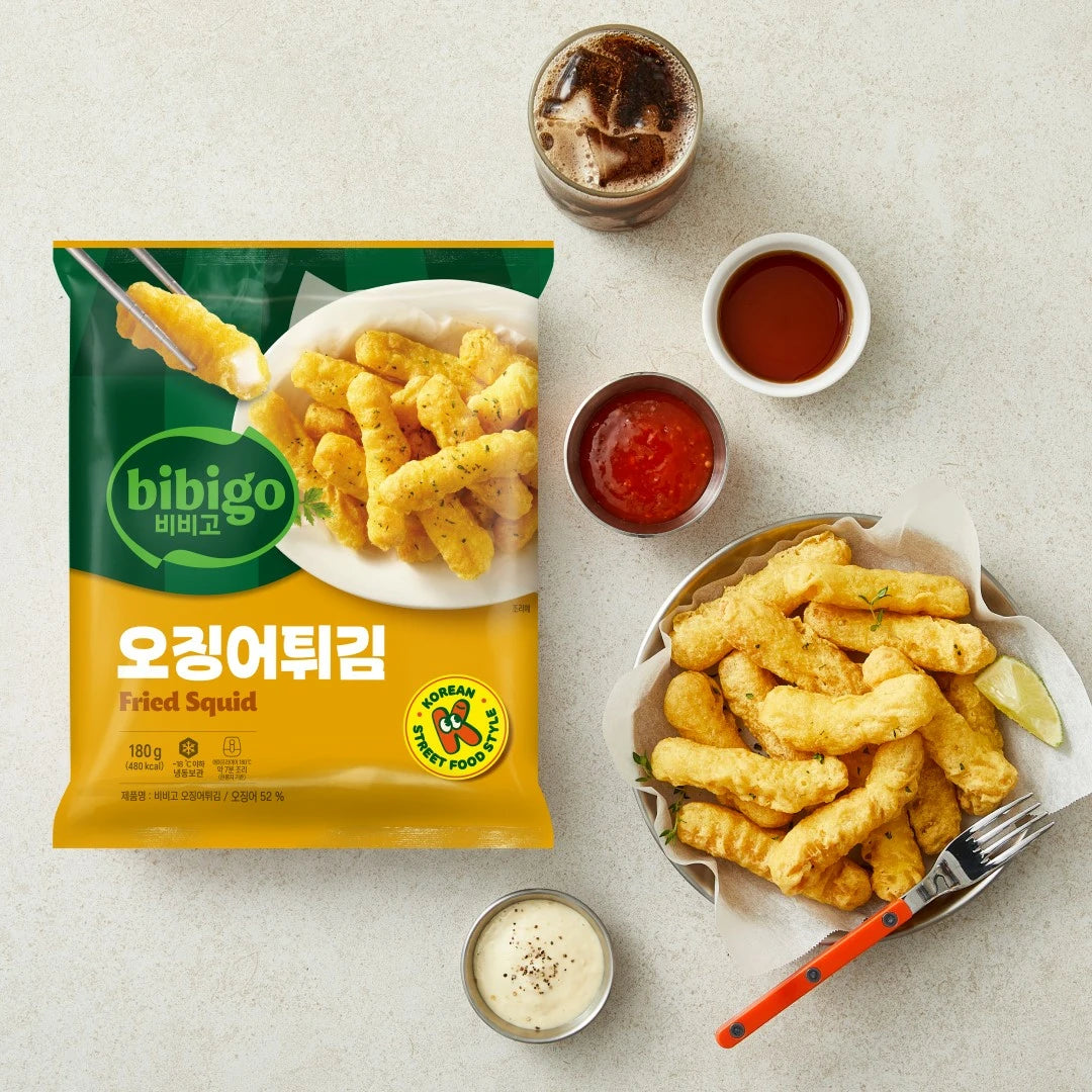 空气炸锅篮中摆放着加热后的金黄色酥炸鱿鱼特写