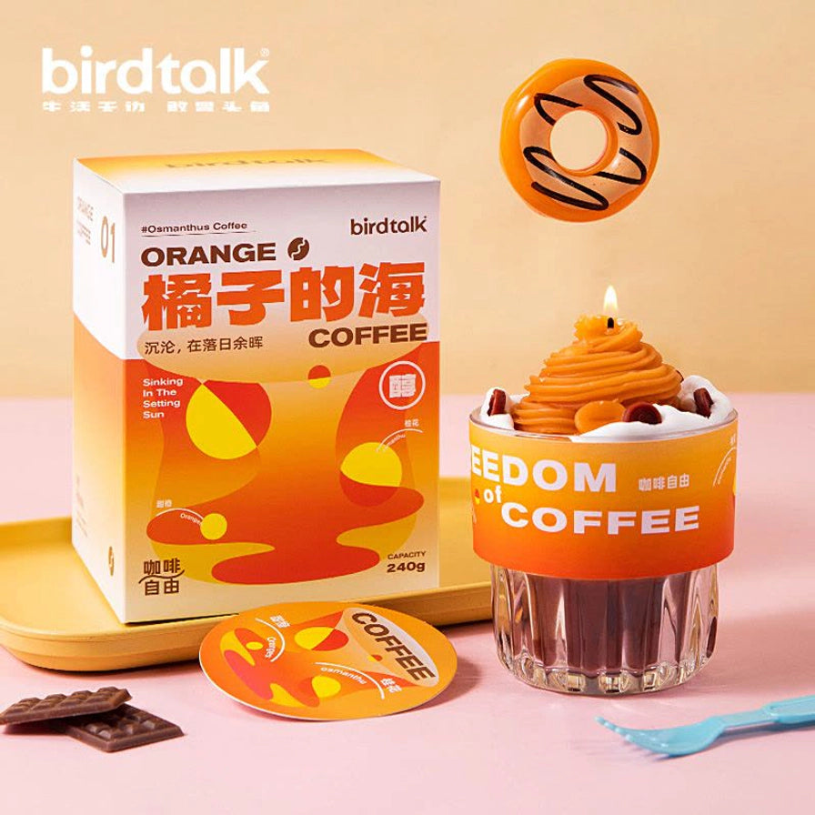 点燃状态的 Birdtalk 咖啡杯香薰蜡烛，旁边配有精致的橙色包装礼盒，营造温馨的居家装饰氛围。