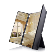 黑色 LED 三折化妆镜展开图，镜面反射卧室背景，边框带有明亮补光灯珠。