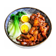 一碗现做的卤肉饭便当，包含色泽红亮的卤肉、半颗卤蛋、青菜和白米饭，盛放在蓝白花纹的瓷碗中，白色背景。
