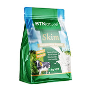 BTNature 1kg 袋装脱脂成人奶粉，包装正面展示了奶牛、牧场和牛奶倒入杯中的图案。