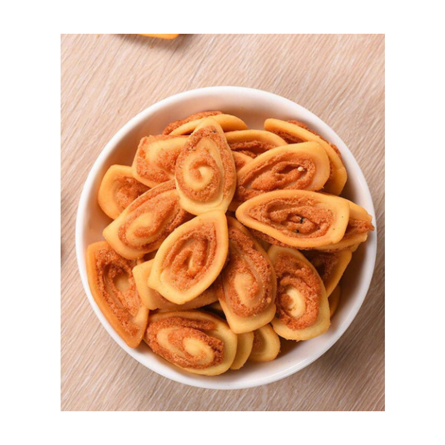 白色碗中盛放着金黄色的猫耳酥饼干，置于木纹桌面上，俯拍视角展示酥脆质感。