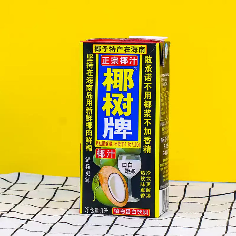 椰树牌椰汁1L纸盒装，放置在黄色背景及黑白格纹桌布上，展示产品侧面及正面包装细节。