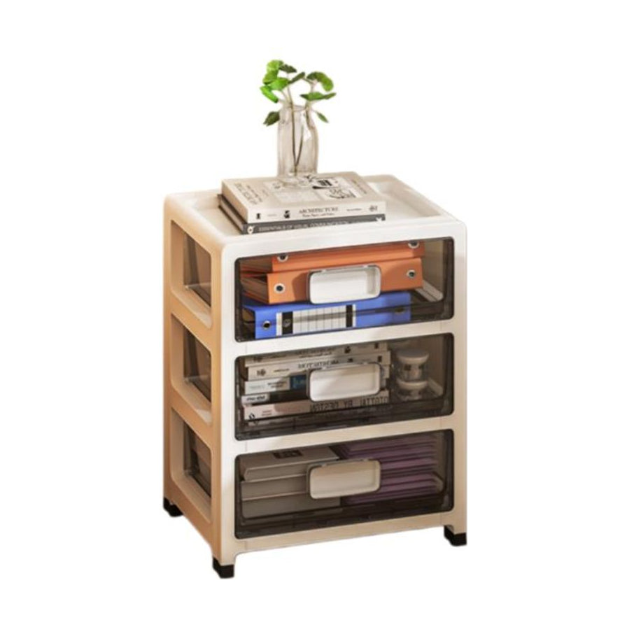 奶油风三层抽屉式收纳柜正面图，半透明抽屉内装有文件夹和书籍，顶部放置书本与绿植装饰。