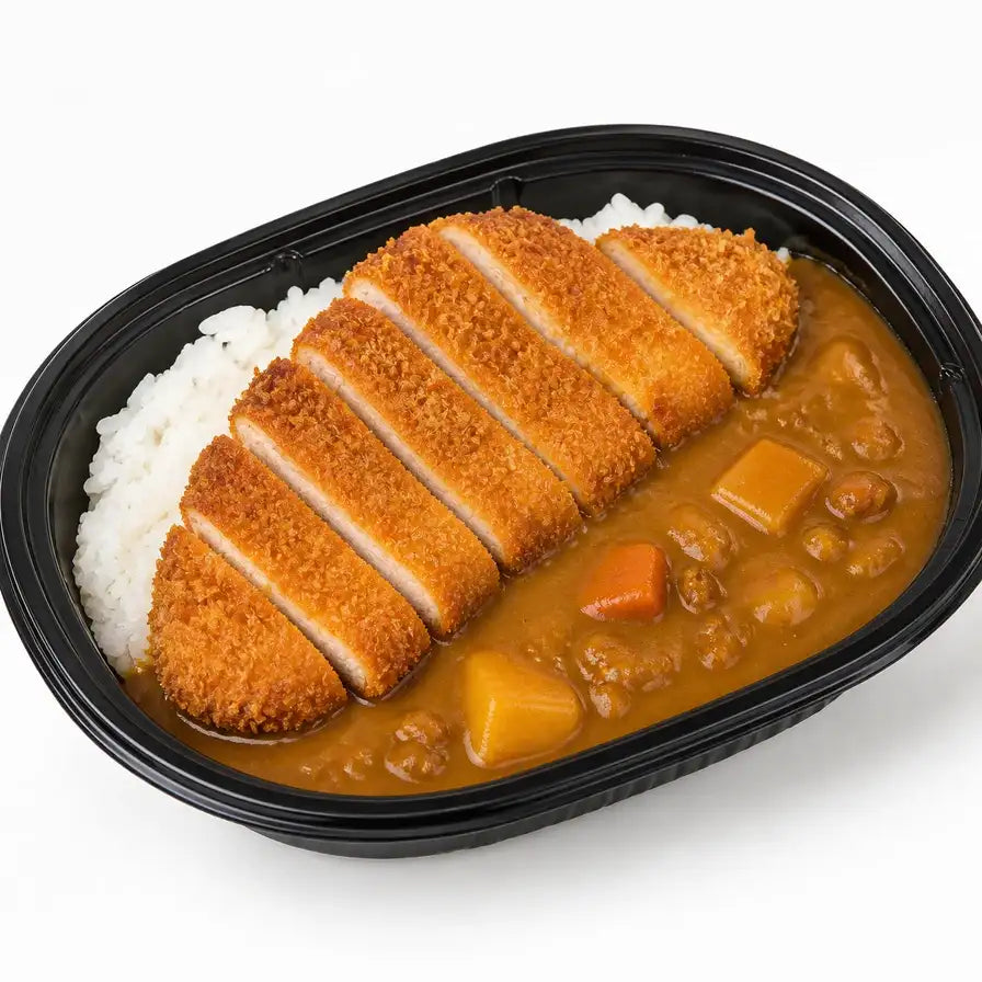 黑色便当盒装盛的咖喱鸡排饭，包含金黄酥脆的切块日式炸鸡排、浓郁的咖喱酱汁、土豆块和白米饭，俯视视角。
