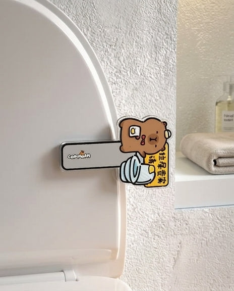 萌系马桶提盖器安装示意图，展示免打孔卡在马桶盖边缘的使用状态