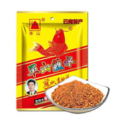 单山蘸水黄色包装袋，印有红色鲤鱼图案，前方摆放一碟红色的干碟辣椒面调味料。