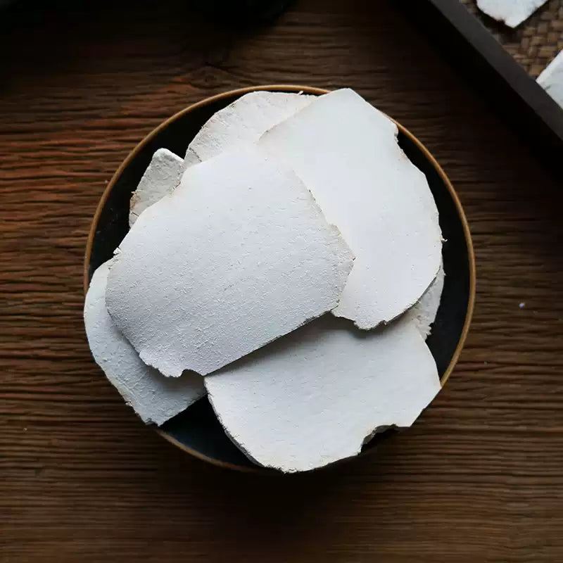 无硫现切茯苓片特写，色泽自然原白，纹理清晰，开袋即用的煲汤食材。