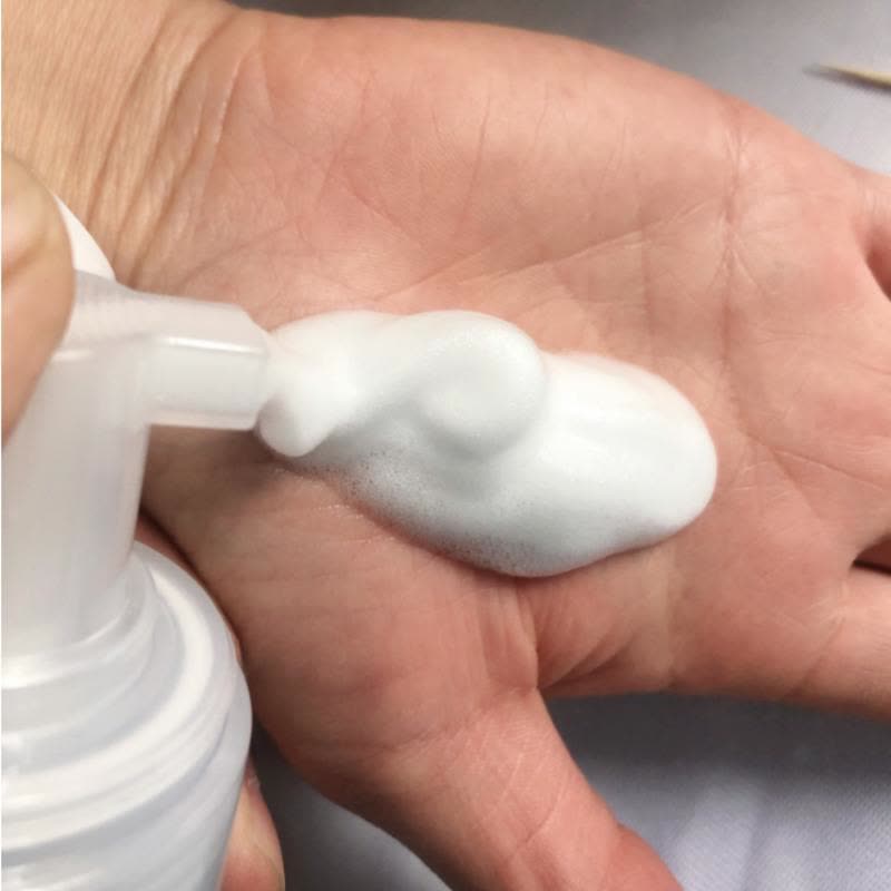 羽绒服袖口油渍清洁效果对比图，展示喷雾使用前后的污渍去除细节。