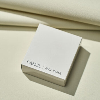 FANCL 吸油面纸包装盒放置在米色背景上的斜侧视图，展示极简设计风格。