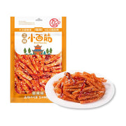 翻天娃芝麻小面筋甜辣味包装袋，前方白色圆盘盛放着裹满芝麻和辣椒丝的条状辣条。