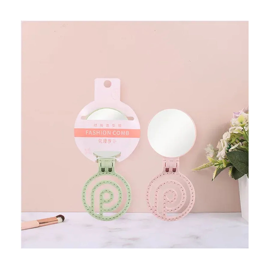 宿舍桌面场景图，粉色和绿色折叠梳镜摆放在大理石台面上，旁边配有化妆刷和花卉装饰。