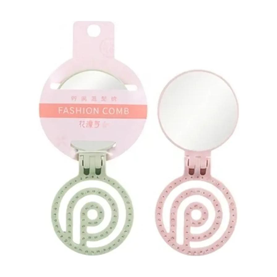 粉色和绿色折叠梳镜套装，展示带包装的闭合状态与展开后的镜面及螺旋梳齿细节。