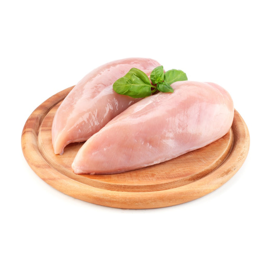 两块新鲜的生鸡胸肉放置在圆形木质托盘上，上方点缀有绿色罗勒叶，背景为纯白色。