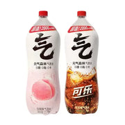 两瓶元气森林2L大容量气泡水，分别为白桃味和可乐味，包装印有醒目的气字、0糖0脂0卡及超值2000ml标识。