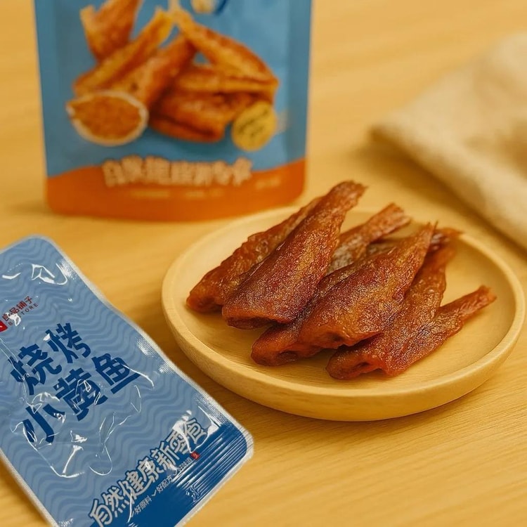 良品铺子烧烤小黄鱼独立小包装特写，展示外酥里嫩的鱼肉纹理与烧烤色泽