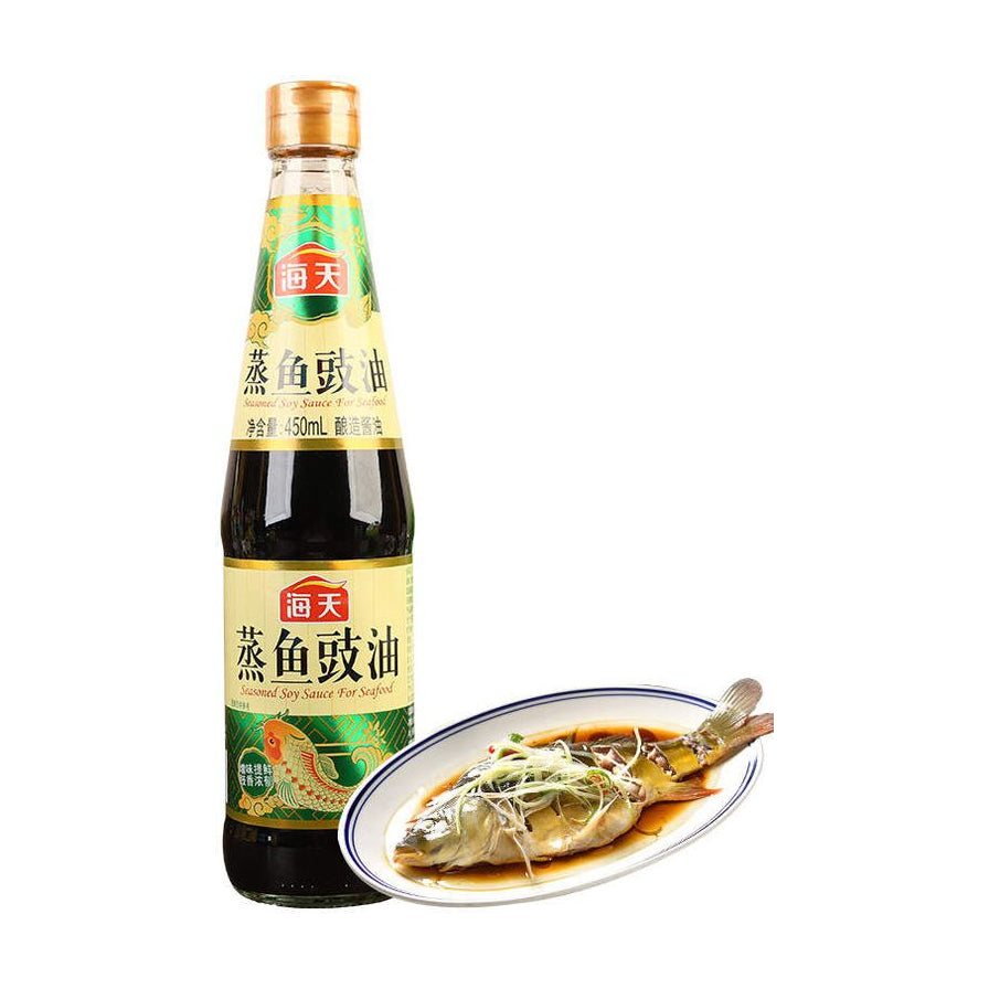 海天蒸鱼豉油瓶装，旁边摆放着一盘淋上豉油的清蒸鱼，展示产品使用效果。