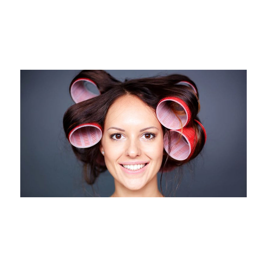 女性面部特写，头发上卷着大号红色和粉色卷发筒