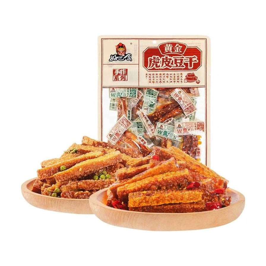 好巴食黄金虎皮豆干混合味装产品图，展示包装袋及盛放在木盘中的麻辣与青花椒味豆干实物。