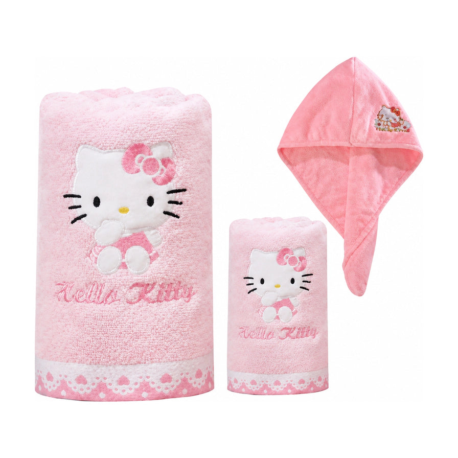 白色背景下的 Hello Kitty 粉色洗浴三件套，包含卷起的浴巾、毛巾和展开的干发帽，均带有精致的凯蒂猫刺绣和蕾丝花边。
