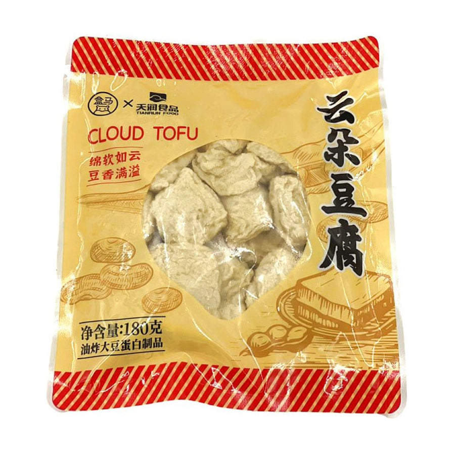 盒马云朵豆腐180g包装正面，显示黄色背景包装袋，印有云朵豆腐、Cloud Tofu字样及产品插画，透明窗口可见内部块状豆腐。